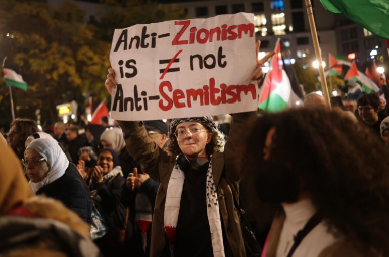 BERLIN, GERMANY - NOVEMBER 04: People, including a young woman holding a sign that reads: