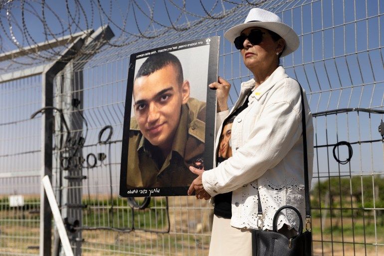 NIR OZ, ISRAEL - APRIL 20: Varda Ben Baruch holds a photo of her grandson Israeli- American hostage Edan Alexander during a rally of families of hostages held in the Gaza Strip at Nir Oz near the border with the Gaza Strip on April 20, 2025 in Nir Oz, Israel. Family members and supporters of Israeli hostages held in Gaza gathered at the border fence near Kibbutz Nir Oz to symbolically call out to their loved ones who remain in Hamas captivity. Fifty-nine people taken captive during the Hamas-led attack on Oct. 7, 2023 remain in Gaza, 24 of whom are thought to be alive. (Photo by Amir Levy/Getty Images)