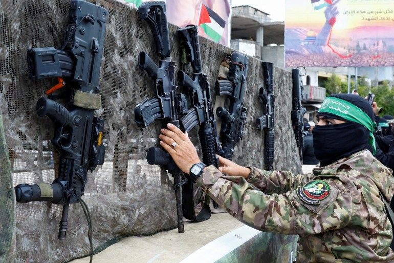 A Palestinian Hamas militant displays guns on the day of the handover of hostages, including those held in Gaza since the deadly October 7 2023 attack, to members of the International Committee of the Red Cross (ICRC) as part of a ceasefire and a hostages-prisoners swap deal between Hamas and Israel, in Rafah in the southern Gaza Strip, February 22, 2025. REUTERS/Hatem Khaled