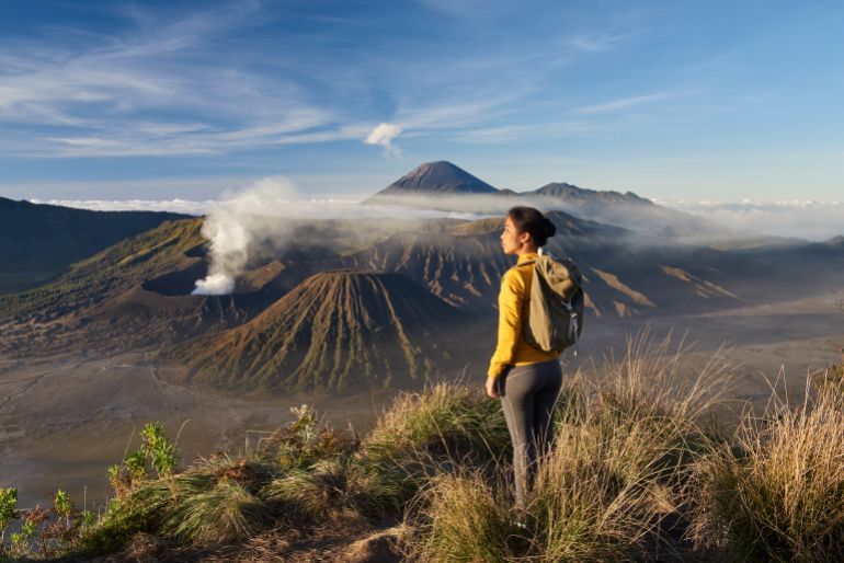 Asia, Indonesia, Java, Bromo Semeru national park, woman trekking at mount Bromo at sunrise, admiring view