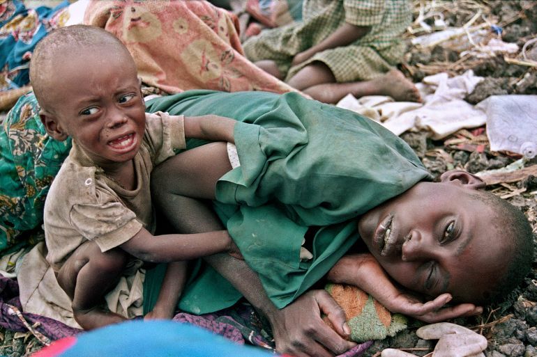 ** FILE ** In this July 27, 1994 file photo, a Rwandan Hutu child desperately tries to awake his mother from a diseased sleep in the Munigi camp, outside Goma, Zaire. Goma, the capital of Congo's North Kivu province, is a beleaguered place in an impoverished and war-ravaged country. But this city of 500,000 always seems to carry on through the destruction, displaying the sheer grit that sustains so many people across the world's poorest continent. (AP Photo/Javier Bauluz, File)