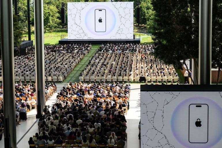 Attendees watch a presentation during the annual Apple