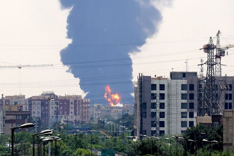 A plume of heavy smoke and fire rise from an oil refinery in southern Tehran, after it was hit in an overnight Israeli strike, on June 15, 2025.