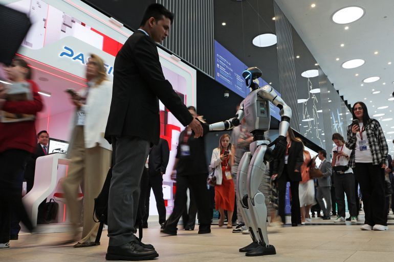 A visitor shakes hands with a robot at the St. Petersburg International Economic Forum (SPIEF) in Saint Petersburg, Russia June 18, 2025. REUTERS/Anton Vaganov