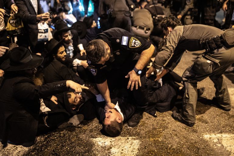 BNEI BRAK, ISRAEL - NOVEMBER 17: Israeli forces intervene with the Haredim as they protest the Israeli Defense Minister Yisrael Katz approved the army's decision to draft 7,000 Ultra-Orthodox Jews (Haredi) into the army, in Bnei Brak, Israel on November 17, 2024. (Photo by Mostafa Alkharouf/Anadolu via Getty Images)