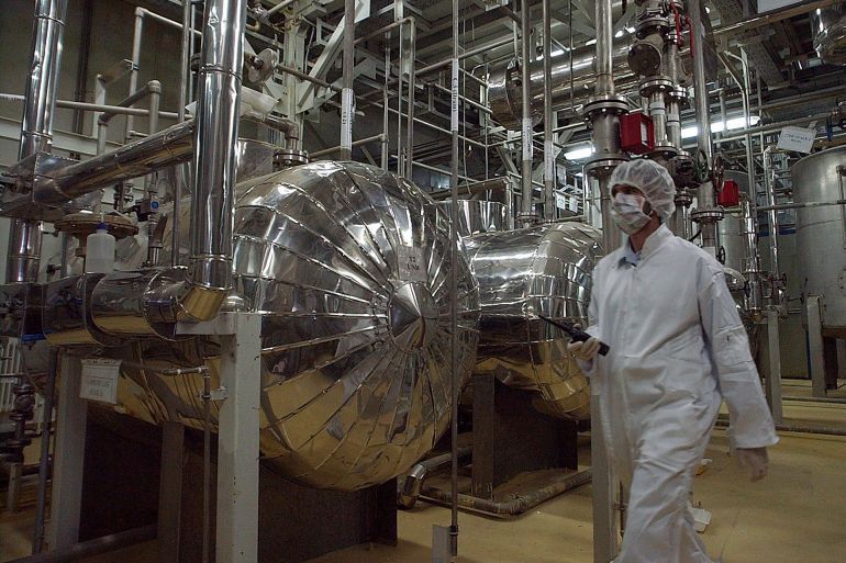 FILE - An Iranian security official in protective clothing walks through part of the Uranium Conversion Facility just outside the Iranian city of Isfahan, March 30, 2005. Iran will elect a new president Friday, June 28, 2024, after the death of hard-line President Ebrahim Raisi. Whoever takes the helm in the country will inherit Iran's rapidly advancing nuclear program, which now enriches uranium closer than ever to weapons-grade levels. (AP Photo/Vahid Salemi, File)