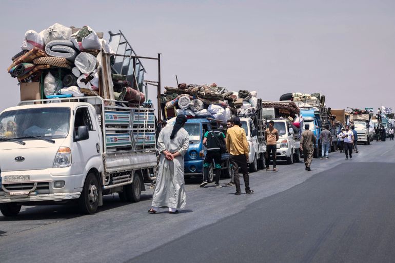 Trucks carrying around 60 displaced families gather on the highway as they head to their village, Kafr Sijna, after more than five years in the Atmeh camps near the Syrian-Turkish border, on a highway north of Kafr Sijna, Syria, Sunday, May 18, 2025. (AP Photo/Ghaith Alsayed)