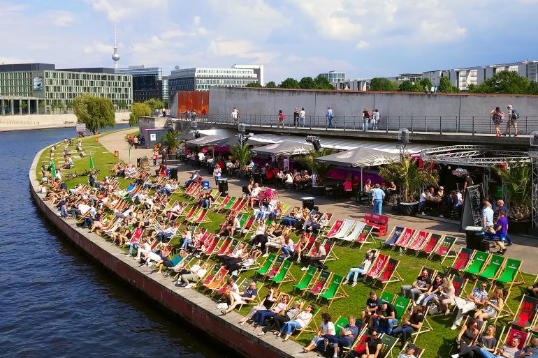 BERLIN, GERMANY - JULY 15, 2017: People relaxing in Spree riverside, having fun and enjoying some drinks in a sunny day