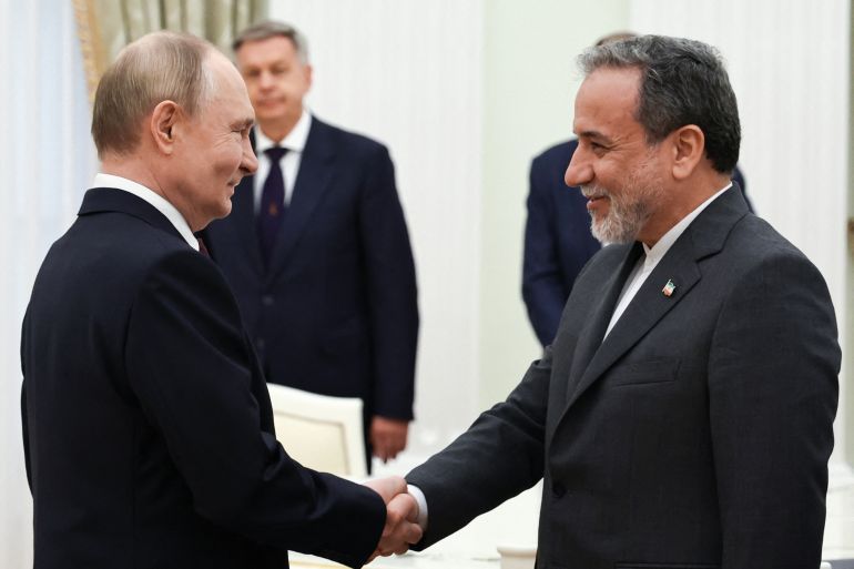 In this pool photograph distributed by the Russian state agency Sputnik, Russia's President Vladimir Putin and Iranian Foreign Minister Abbas Araghchi shake hands during a meeting at the Kremlin in Moscow on June 23, 2025. (Photo by Alexander KAZAKOV / POOL / AFP)