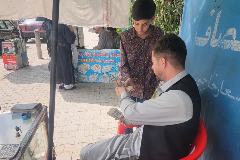صرّاف أفغاني يتعامل مع أحد العملاء في أحد أسواق كابل حركة يومية تعكس اعتماد المواطنين المتزايد على الصرافة التقليدية وسط أزمة ثقة بالبنوك
