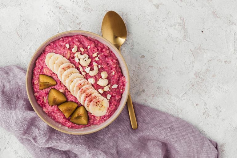 Healthy breakfast - pink oatmeal on a light background with banana, nuts and beetroot powder.; Shutterstock ID 1233393166; purchase_order: aj; job: ; client: ; other: