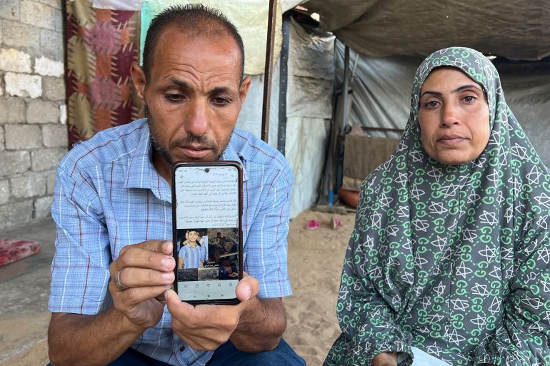 يوسف الزعانين، يعرض صورة ابنه محمد الذي قتله الاحتلال بينما كان ينتظر الحصول على كيس من الطحين لسد رمق أسرته