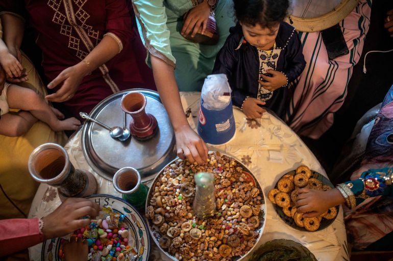 In this Tuesday, Sept. 10, 2019 photo, woman and children eat dried fruits and treats at a home to celebrate the occasion of Ashura, in Sale, near Rabat, Morocco. On Sept. 9, the Arab and Muslim world marked Ashura, a day commemorating the death of Imam Hussein, the grandson of the Prophet Muhammad and one of Shia Islam's most important figures. (AP Photo/Mosa'ab Elshamy)