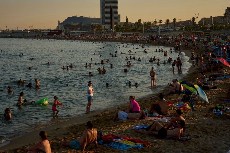 Swimmers cool off in the water at a beach on a hot day in Barcelona, Spain, Sunday, June 29, 2025. (AP Photo/Emilio Morenatti)