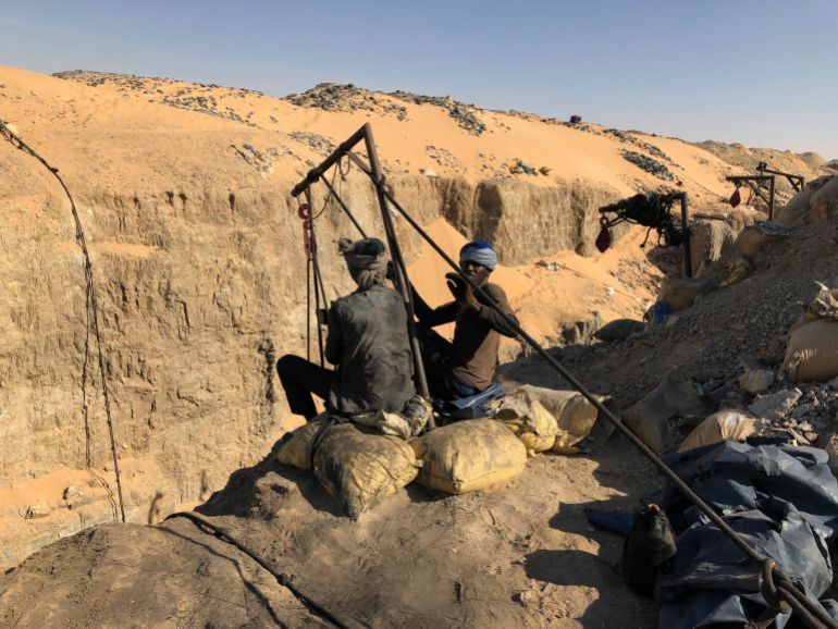 Akjoujt, Mauritania - September 21, 2020: artisanal miners in the Inchiri region pulling up ore from the bottom of a pit.