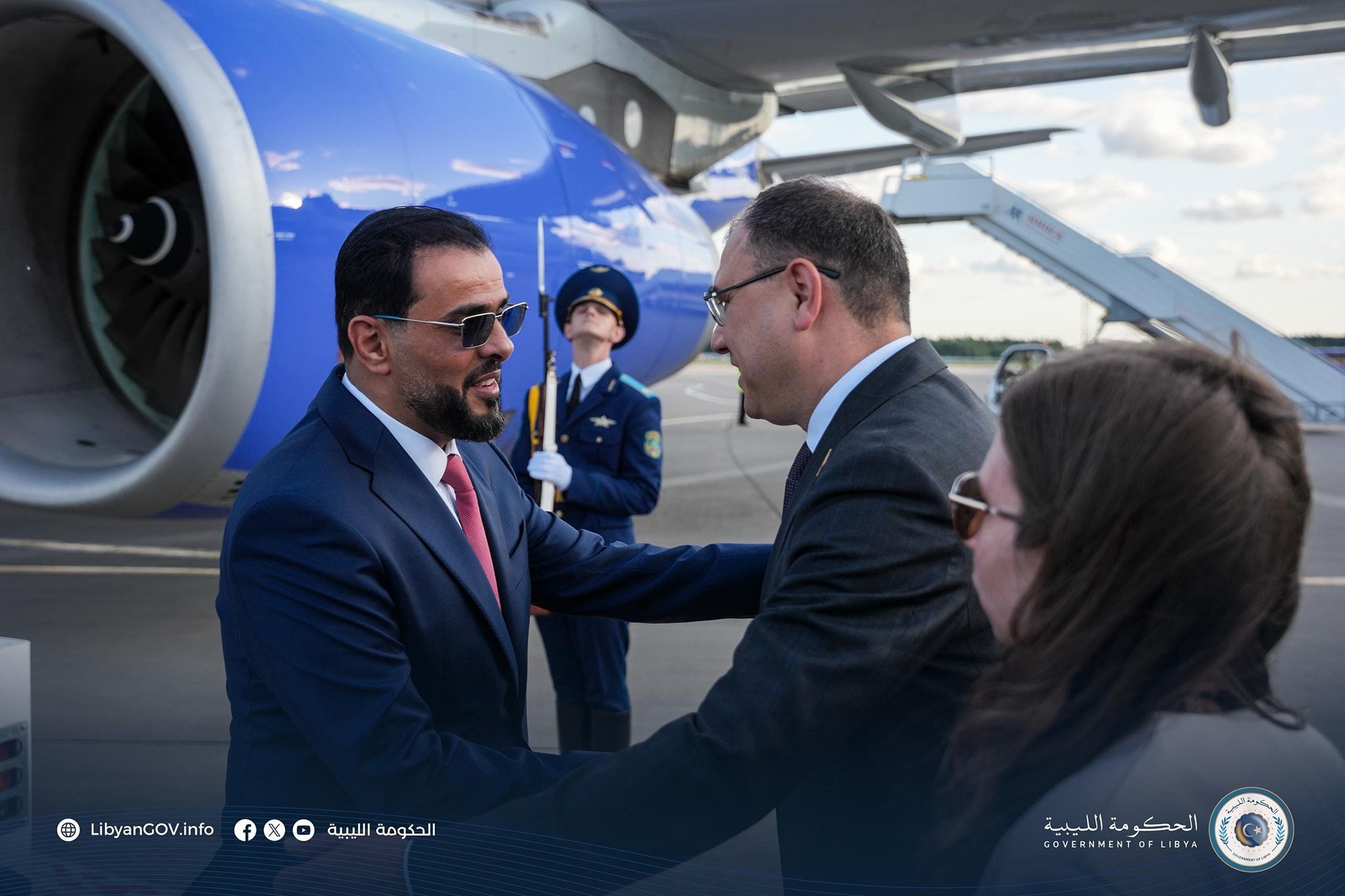 May be an image of ‎2 people, aircraft and ‎text that says '‎LibyanCoV.info الحكومة الليبية الحكومة OF GOVERNMENTOFLIBYA الحكومة_اللييية الليبية‎'‎‎