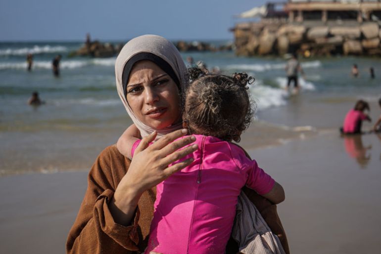 GAZA - JUNE 21: 31-year-old Madleen Kullab, a woman fisher from Gaza who lent her name to the humanitarian ship Madleen launched by the Freedom Flotilla Coalition, embraces her child on the Gaza coast on June 21, 2025. Despite the ship not reaching Gaza, Kullab believes it succeeded in mobilizing global attention. She began fishing at the age of six and was forced to continue the profession alone at 13 after her father became bedridden. Madleen is the only female fisherman in Gaza. (Photo by Anas Zeyad Fteha/Anadolu via Getty Images)