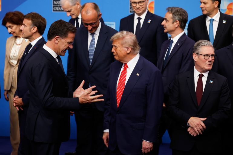 President Donald Trump, center, speaks with NATO Secretary General Mark Rutte, left, during a group photo of NATO heads of state and government at the NATO summit in The Hague, Netherlands, Wednesday, June 25, 2025. (AP Photo/Geert Vanden Wijngaert)