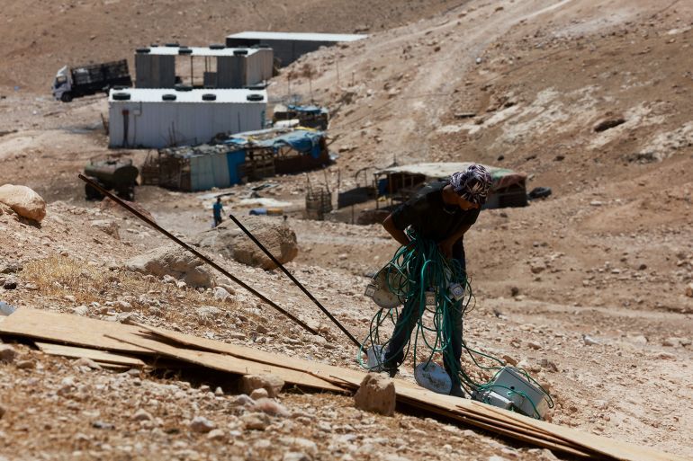 A Palestinian holds cables as Palestinian Bedouins prepare to flee their homes, while settler violence surges, near Jericho in the Israeli-occupied West Bank, July 4, 2025. REUTERS/Ammar Awad