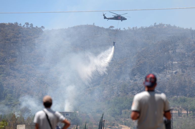 A Turkish helicopter helps battle a forest fires in the coastal Syrian province of Latakia on July 5, 2025. Syrian emergency workers were battling forest fires raging in the coastal province of Latakia on Saturday for a third day in tough conditions as neighbouring Turkey sent assistance. Syria's ministry for emergencies and disaster management said teams from Turkey began helping on Saturday morning