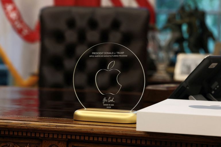 A gift given by Apple CEO Tim Cook to U.S. President Donald Trump stands on President Trump's table, as they present Apple's announcement of a $100 billion investment in U.S. manufacturing, in the Oval Office at the White House in Washington, D.C., U.S., August 6, 2025. REUTERS/Jonathan Ernst