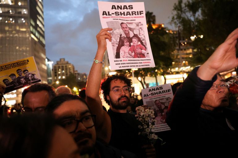A demonstrator holds a poster with the photo of Al Jazeera Arabic correspondent Anas al-Sharif, who was killed along with his colleagues during an Israeli airstrike in Gaza on Sunday, amid the ongoing conflict between Israel and Hamas, at the Angel of Independence monument in Mexico City, Mexico, August 12, 2025. REUTERS/Luis Cortes