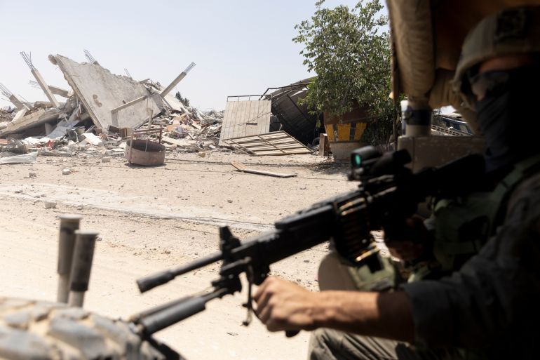 KHAN YUNIS, GAZA - JUNE 8: (EDITOR'S NOTE: Image has been reviewed by Israeli Defense Forces prior to transmission) An Israeli soldier guards as he sits in an army vehicle while escorting members of the press towards Gaza European Hospital near Khan Yunis on June 8, 2025 in Khan Yunis, Gaza. According to the Israeli military, it struck Hamas 
