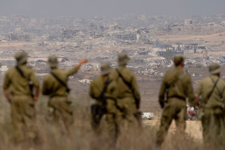 SOUTHERN ISRAEL, ISRAEL - AUGUST 13: Israeli soldiers look at destructed buildings in the Northern Gaza Strip as they are standing at a view point on the Israeli side of the border on August 13, 2025 in Southern Israel, Israel. Last week Israel's security cabinet approved Prime Minister Benjamin Netanyahu's proposal to expand IDF occupation of the Gaza Strip, including taking 