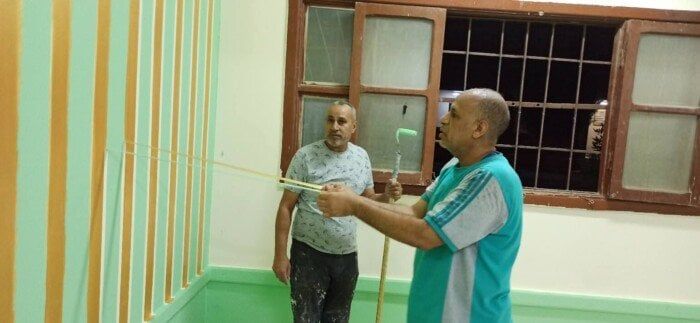 مدير مدرسة بقنا يشارك معلميه في دهان الفصول استعدادًا للعام الدراسي الجديد