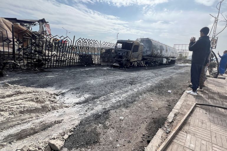 People stand outside a fuel station one day after it was hit by Israeli airstrikes in Sanaa, Yemen August 25, 2025. REUTERS/Stringer
