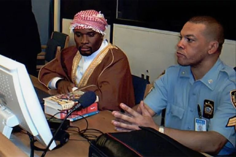 ARUSHA, TANZANIA, UNITED REPUBLIC OF: Hassan Ngeze (L), former member of the MRND and founding member of coalition for the Defence of the Republic and a editor for the Kangura newspaper sit 03 December 2003 in the UN Tribunal for Rwanda in Arusha, guarded by a UN security. Mr. Ngeze was sentenced to life imprisonement together with another member of the Rwandan media, Ferdinand Nahimana (not pictured) for conspiracy to commit Genocide and public incitement to commit Genocide at the end of the