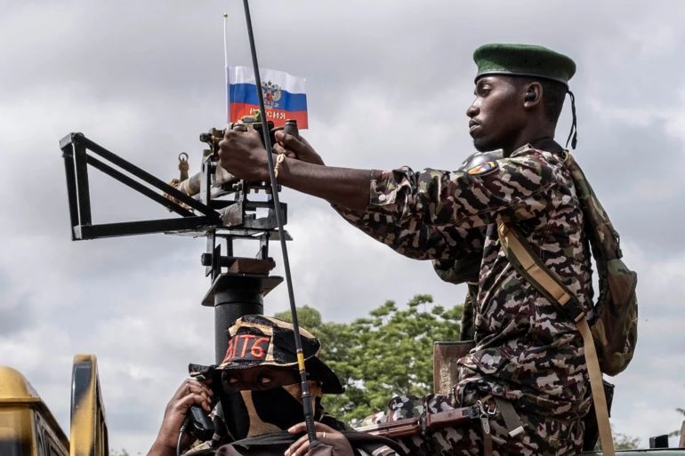 A fighter of the Central African Republic in Africa against the backdrop of the Russian flag. December 2022. Photo credits: Barbara Debout/AFP/Getty Images